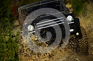 Competition, energy and motorsport concept. Off road vehicle or SUV crossing puddle with dirt splash. Car racing in