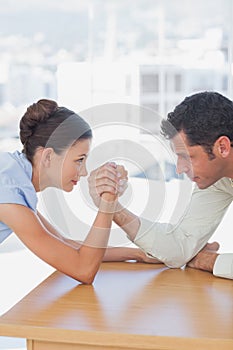 Competitive business people arm wrestling