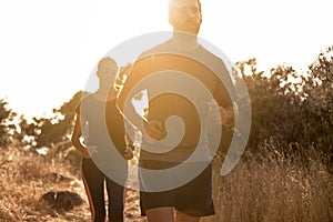 Competitive couple jogging out in nature