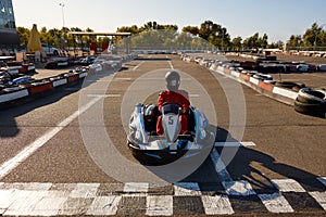 Competitive man racing in go-carts at finish of motor race track