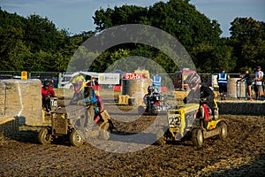 Competitive Mud spattered Lawn Mower Racing