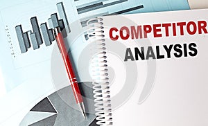 COMPETITOR ANALYSIS text on a notebook with pen on a chart background