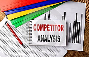 COMPETITOR ANALYSIS text on a notebook with pen, folder on a chart background