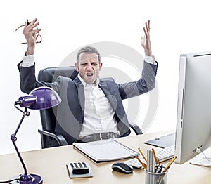 Complaining businessman sitting at office, raising annoyed hands for exasperation