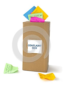 COMPLAINT BOX with many notes sticking out of the top slot and laying beside it