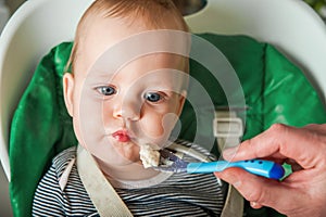 Complementary feeding of child, baby food. The Infant is spoon-fed