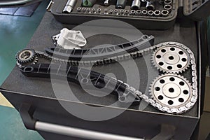 A complete new timing chain replacement kit is laid out on a gray tool cart