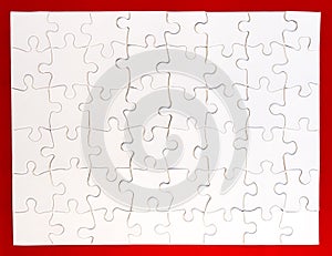 Completed White Jigsaw Puzzle on Red Background