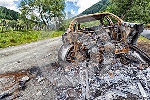 Completely burned car on the country road
