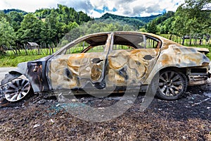 Completely burned car on the country road