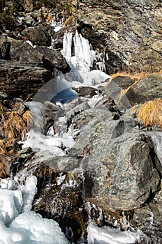 Completely frozen mountain stream in winter