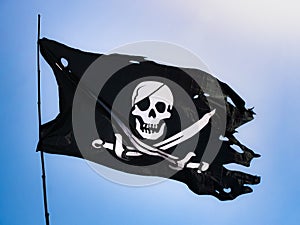 Completely torn and bruised black colored pirate flag (Jolly Roger)