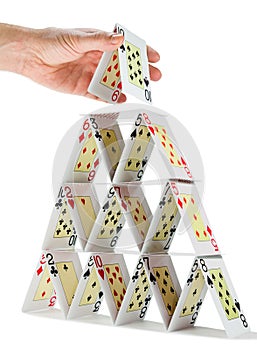 Completing a house of cards isolated on white