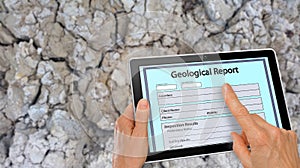 Completing online Geological Report on a computer tablet photo