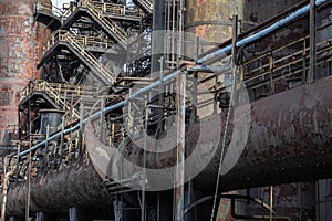 Complex background of rusty metal pipes, walkways, urban industrial architecture