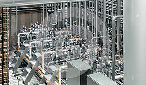 Complex bottling machinery at brewery, automated equipment for filling and capping beer bottles, precision and modern photo