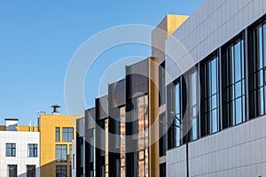 Complex of buildings of different storeys. Ventilated facades in different colours with large glazing area for design on photo