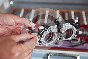 Complex device. Female hands holding the optical device for eye testing