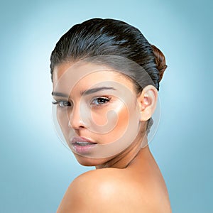 The complexion of perfection. Studio shot of an attractive young woman with a perfect complexion posing against a blue