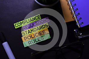 Compliance, Regulations, Strandards, Policies, Rules text on sticky notes isolated on Black desk. Mechanism Strategy Concept photo