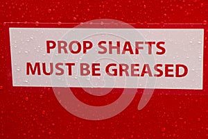 Compliance sign reminder to Grease Prop Shafts Daily for preventative measures. Concept of looking after machinery