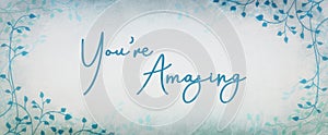 Compliment or encouragement typography  design saying you`re amazing in cursive handwriting with ivy or vine border design and blu photo