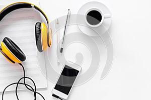 Compose music. Headphones, music notes, phone and coffee on white background top view copyspace