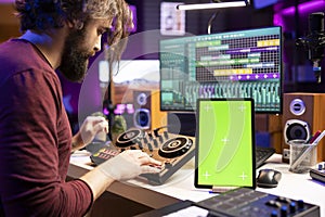 Composer creating soundtracks on stereo gear and greenscreen display