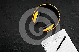 Composer office desk . Workplace of musician with headphones and notes black background top view mockup