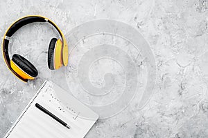 Composer office desk . Workplace of musician with headphones and notes stone background top view mockup