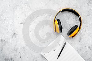 Composer office desk . Workplace of musician with headphones and notes stone background top view mockup