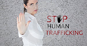 Composite of caucasian businesswoman showing stop sign and stop human trafficking text