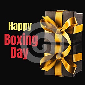 Composite of gift boxes and happy boxing day text on black background, copy space