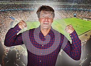 Composite with happy and excited soccer fan man and football pitch background celebrating his team scoring and winning in sport