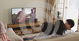 Composite of happy family sitting at home together watching hockey match on tv