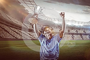 Composite image 3D of portrait of happy sportsman cheering while holding trophy