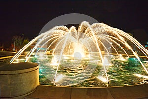 A composite image of 5 different exposures of a fountain at night.