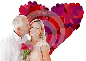 Composite image of affectionate man kissing his wife on the cheek with roses