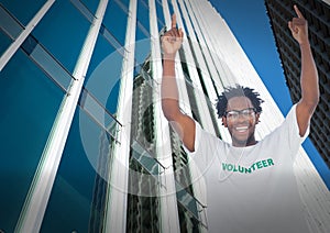 Composite image of afican american male volunteer celebrating against tall buildings in background