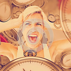 Composite image of angry blonde screaming and holding her head