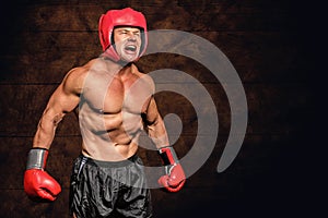 Composite image of angry boxer against black background