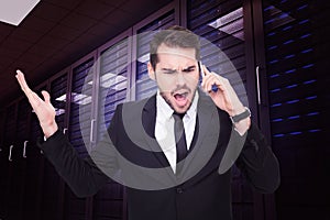 Composite image of angry businessman gesturing on the phone