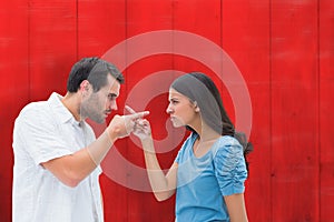 Composite image of angry couple pointing at each other