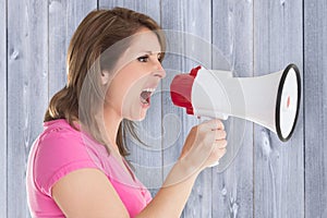 Composite image of angry woman with megaphone