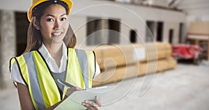 Composite image of architect woman with yellow helmet and plans