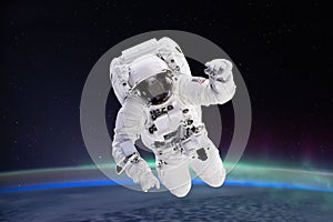 Composite image of astronaut floating in space, earth planet in the background,  Elements of this image are furnished by NASA