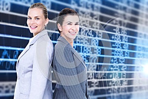 Composite image of attractive businesswomen standing back-to-back