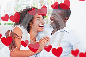 Composite image of attractive couple cuddling on the couch