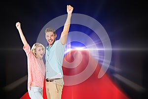 Composite image of attractive couple smiling and cheering