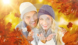 Composite image of attractive couple in winter fashion smiling at camera